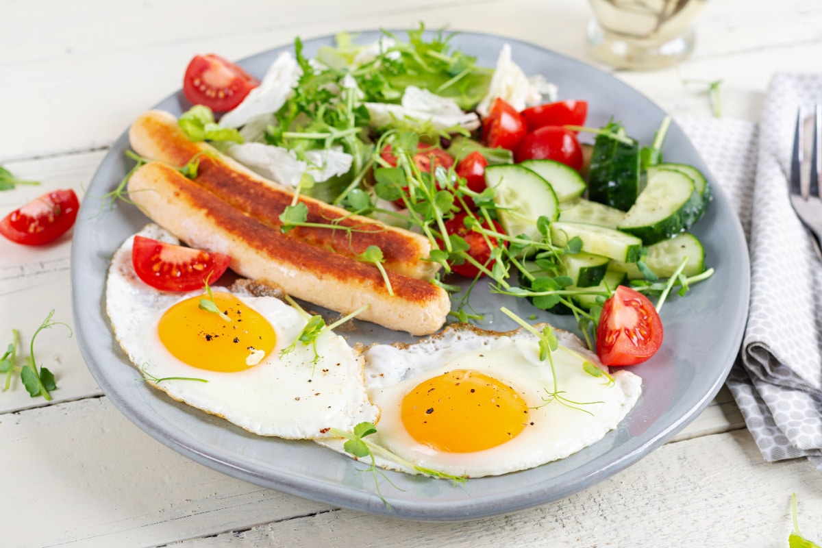 Ketofrühstück Spiegeleier, Bratwurst und frischer Salat